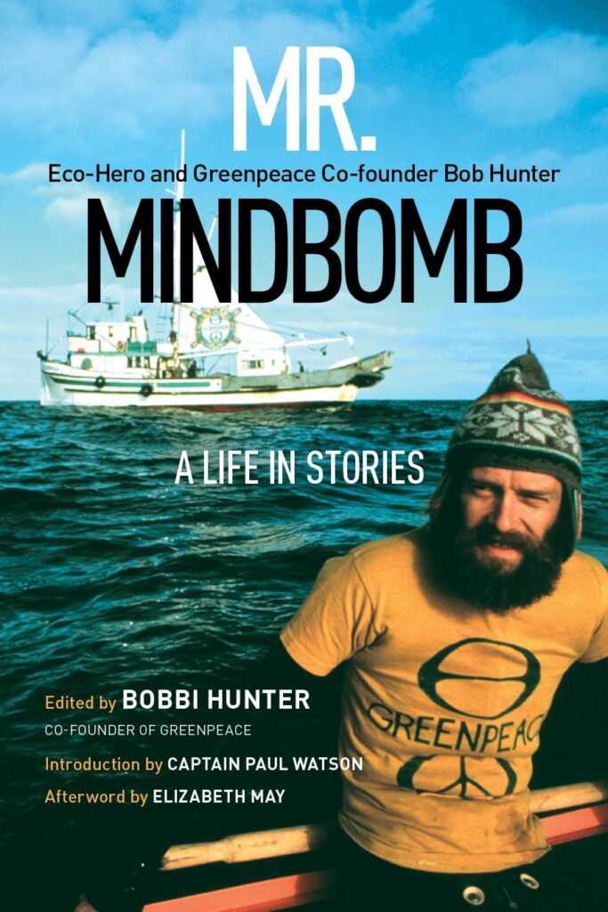 A book cover of "Mr. Mindbomb" with a man in a yellow shirt and a toque on the water with a larger boat behind him.