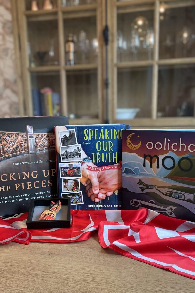 Three indigenous books on a oak table